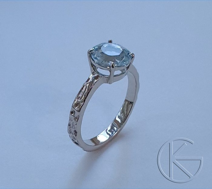 Valgest kullast sõrmus topaasiga